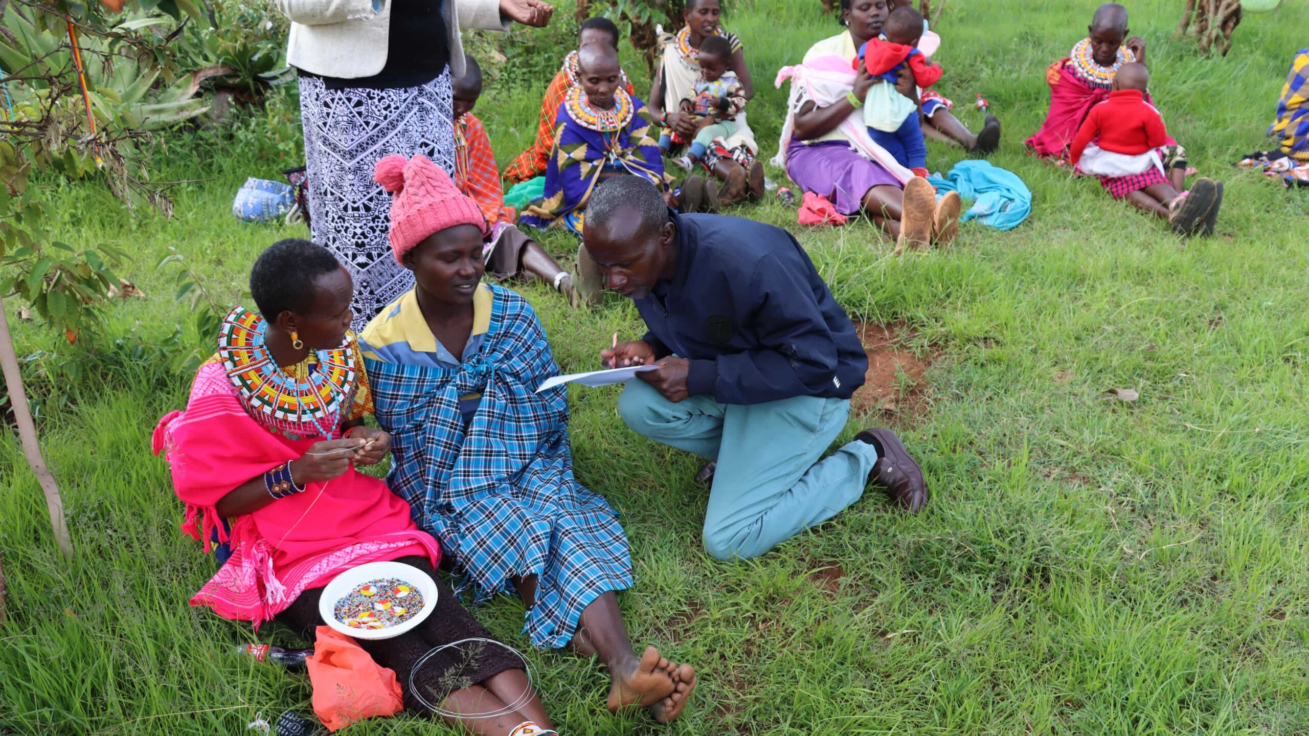 Women sitting in the grass with researcher